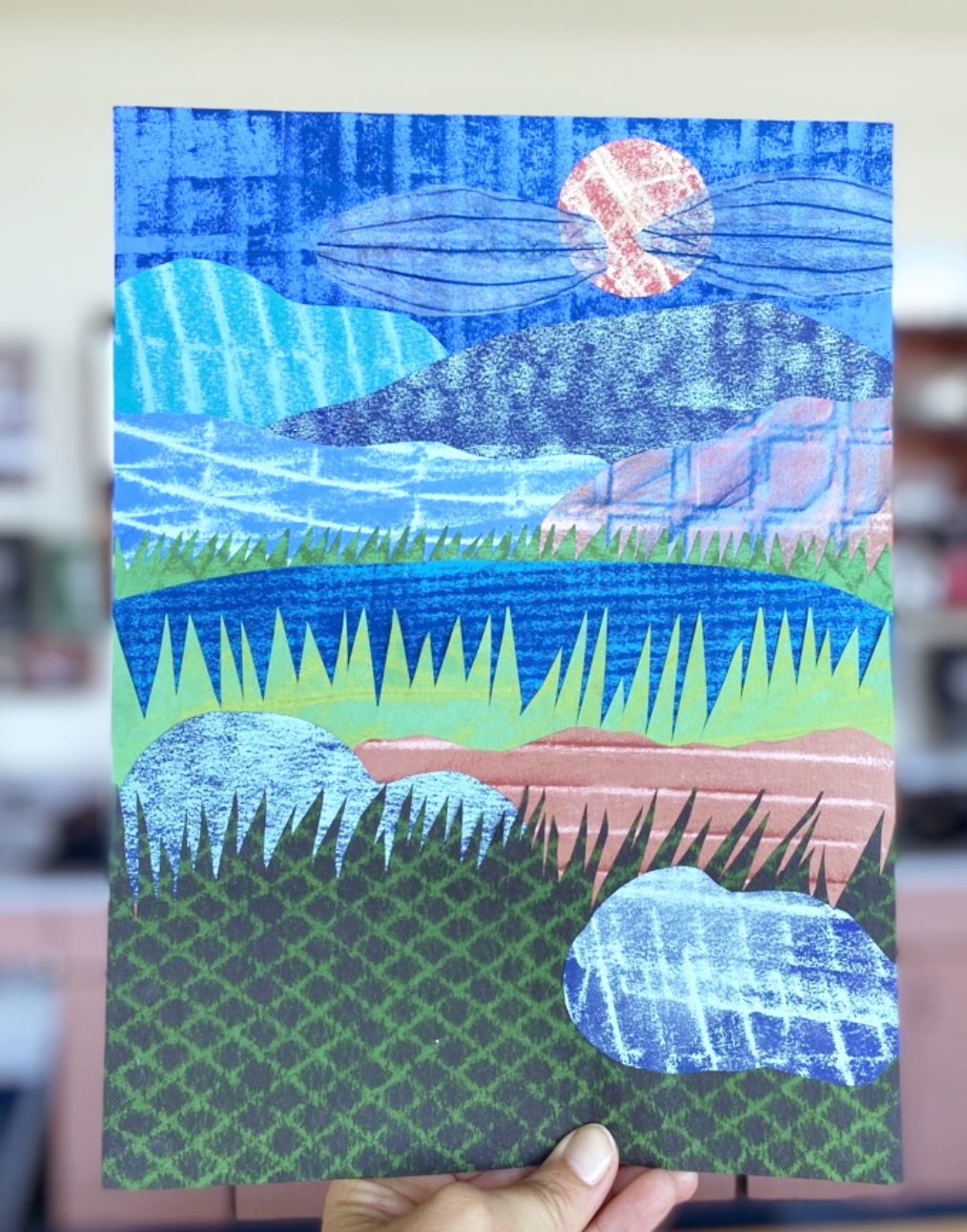 A landscape collage made up of cut paper with textures made from the surrealist frottage technique 